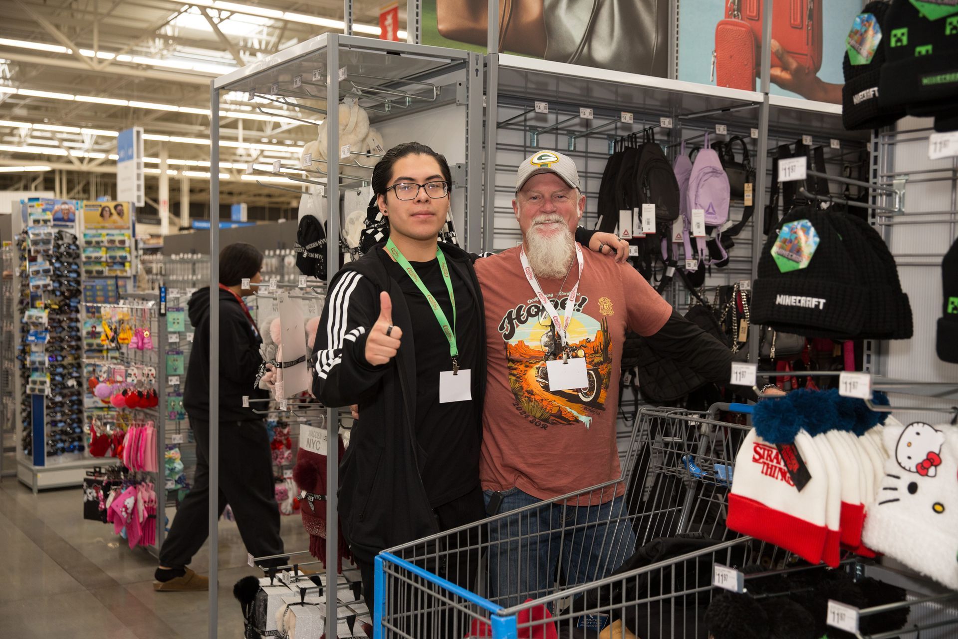 Two men are standing next to each other in a store giving a thumbs up.