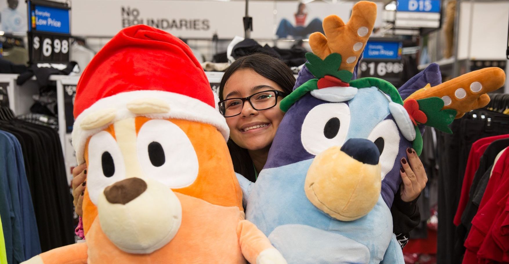 A woman is holding two stuffed animals in a store.