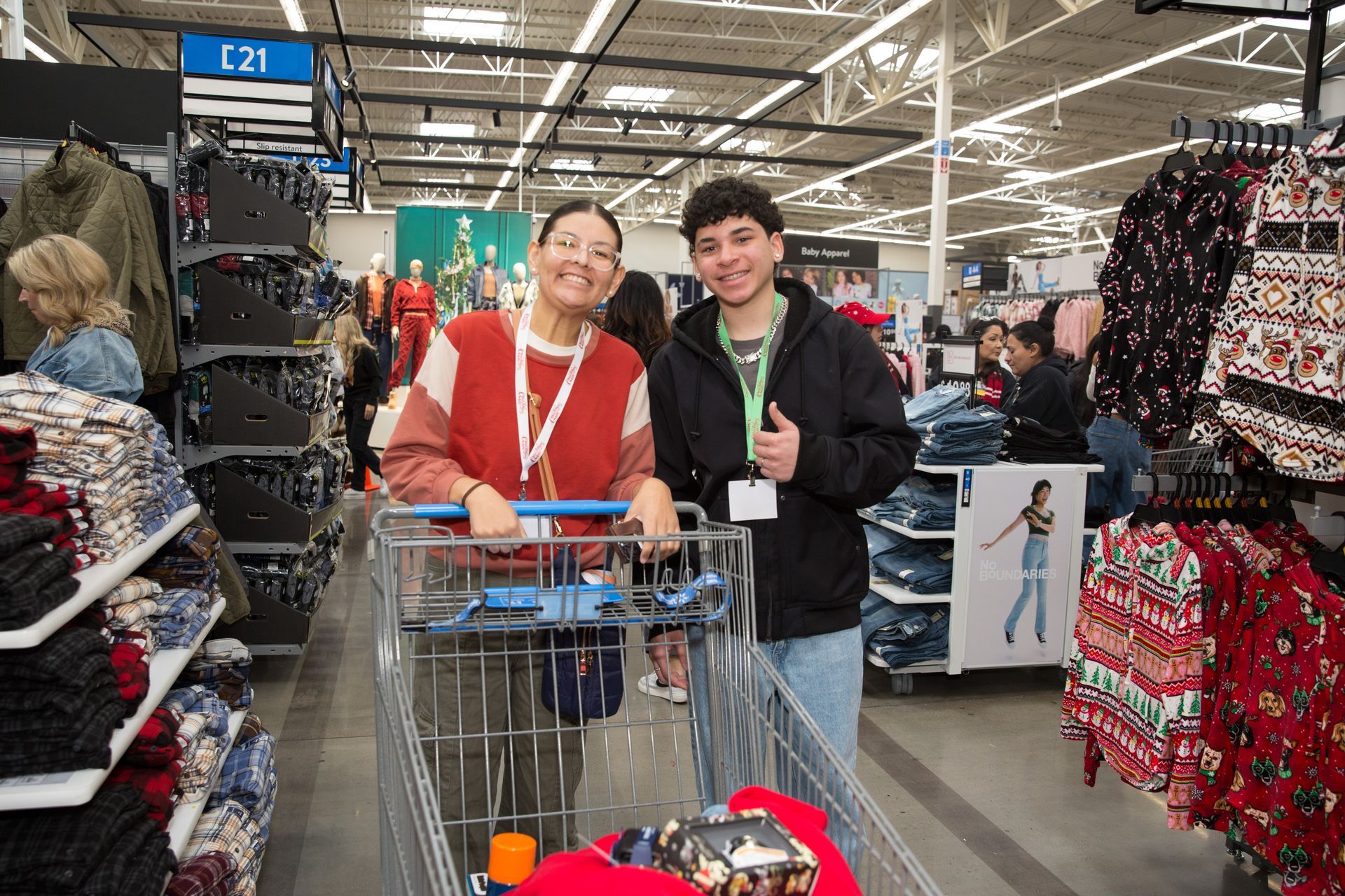 A man and a woman are pushing a shopping cart in a store.