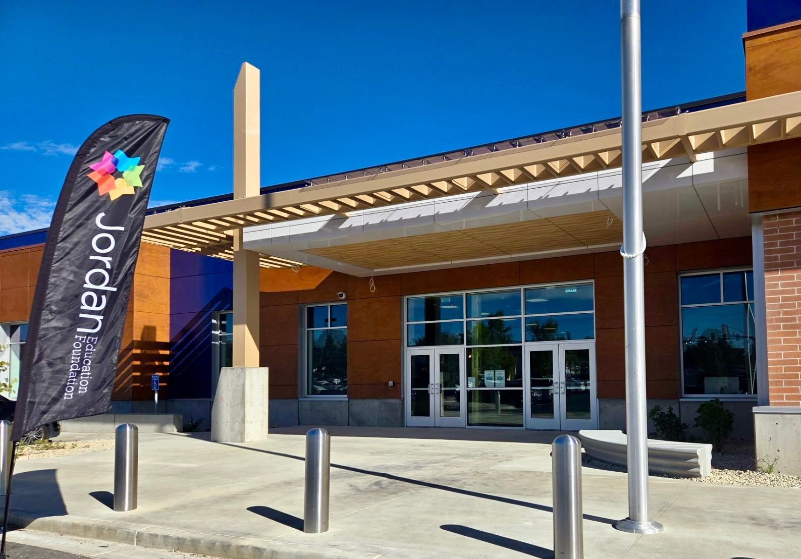 Jordan School District building entrance with a Jordan Education Foundation Flag out front.