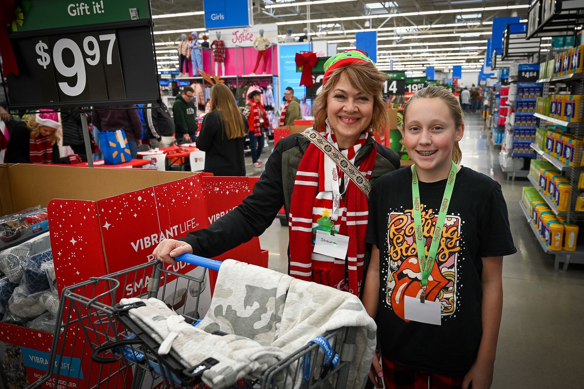 A woman is pushing a shopping cart with a child in it in a store.
