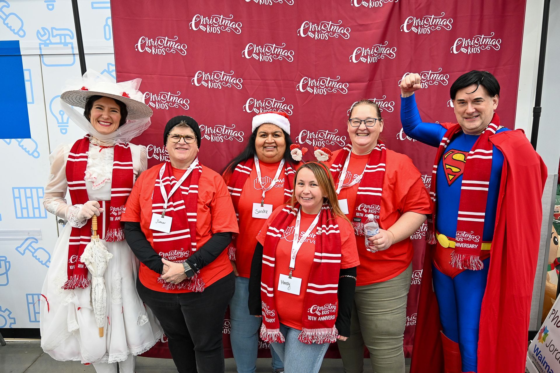 A group of people are posing for a picture in front of a red backdrop.