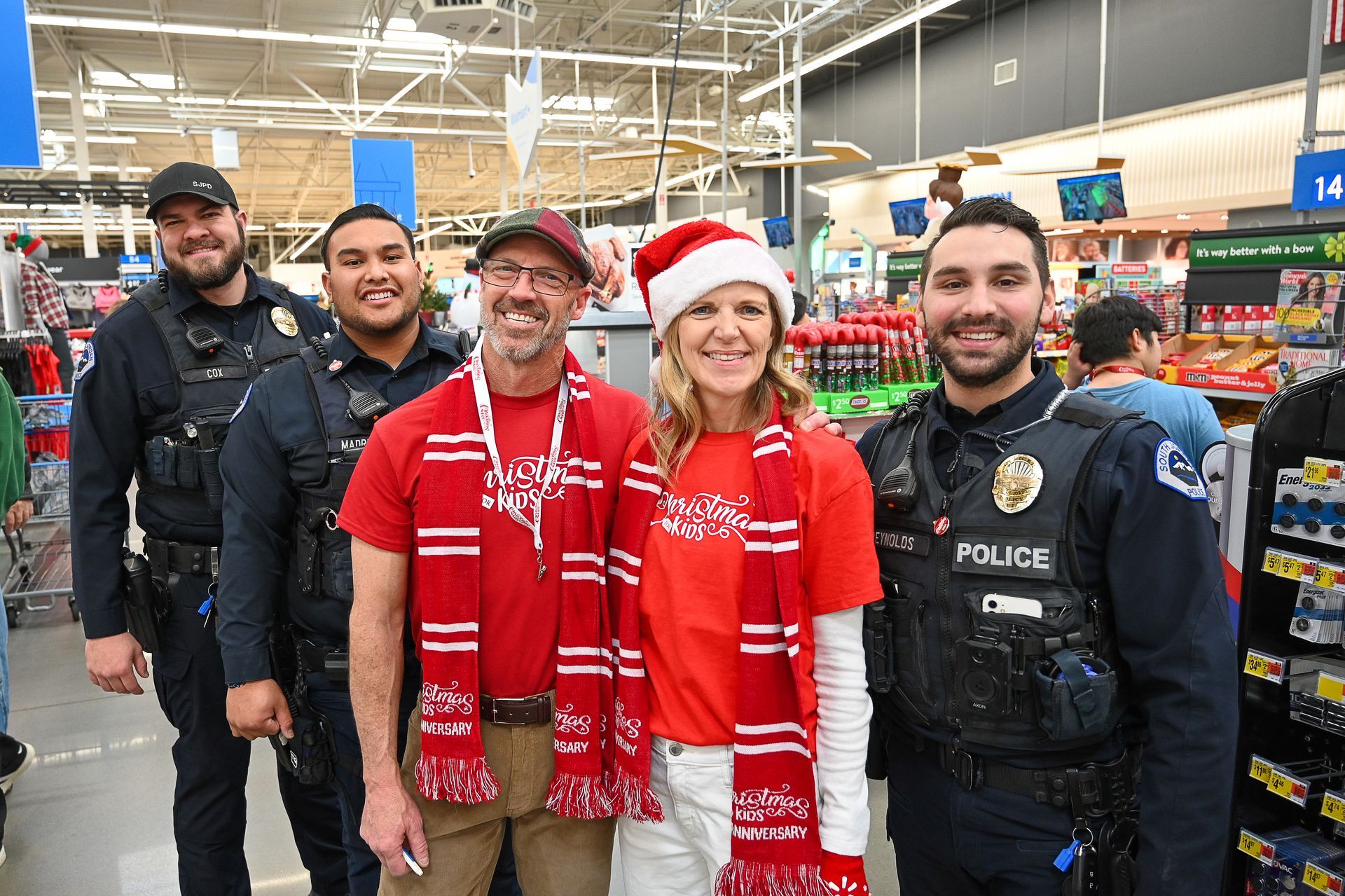 A group of police officers and a woman are posing for a picture in a store.