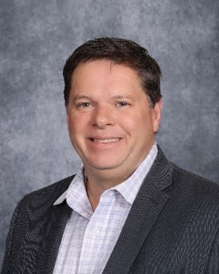 A man in a suit and tie is smiling for the camera.