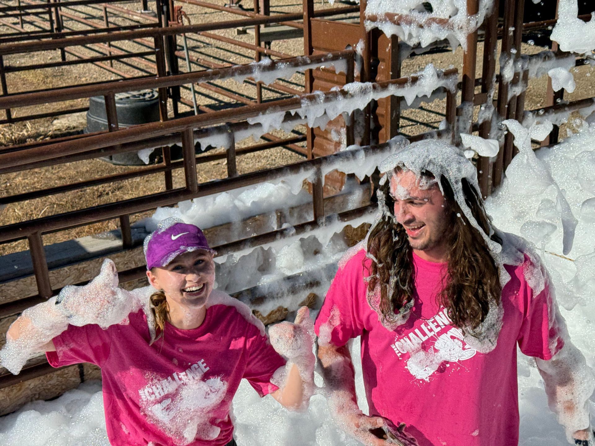 A man and a woman are standing next to each other covered in foam.