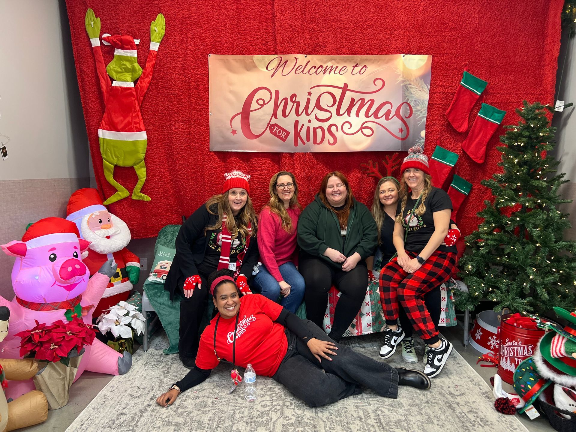 A group of women are posing for a picture in a room decorated for christmas.