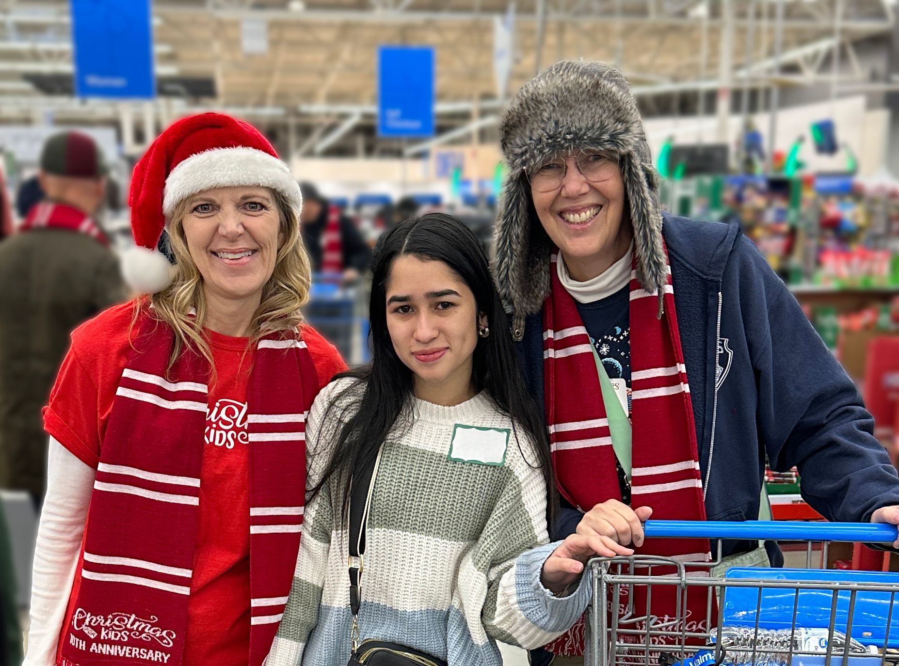 Three women and a girl are posing for a picture in a store.