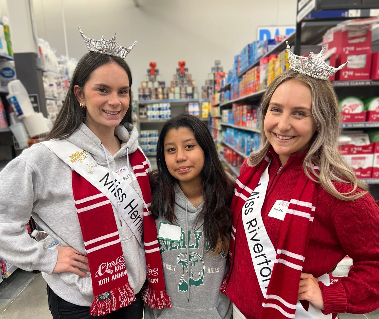 Three women are posing for a picture in a store.