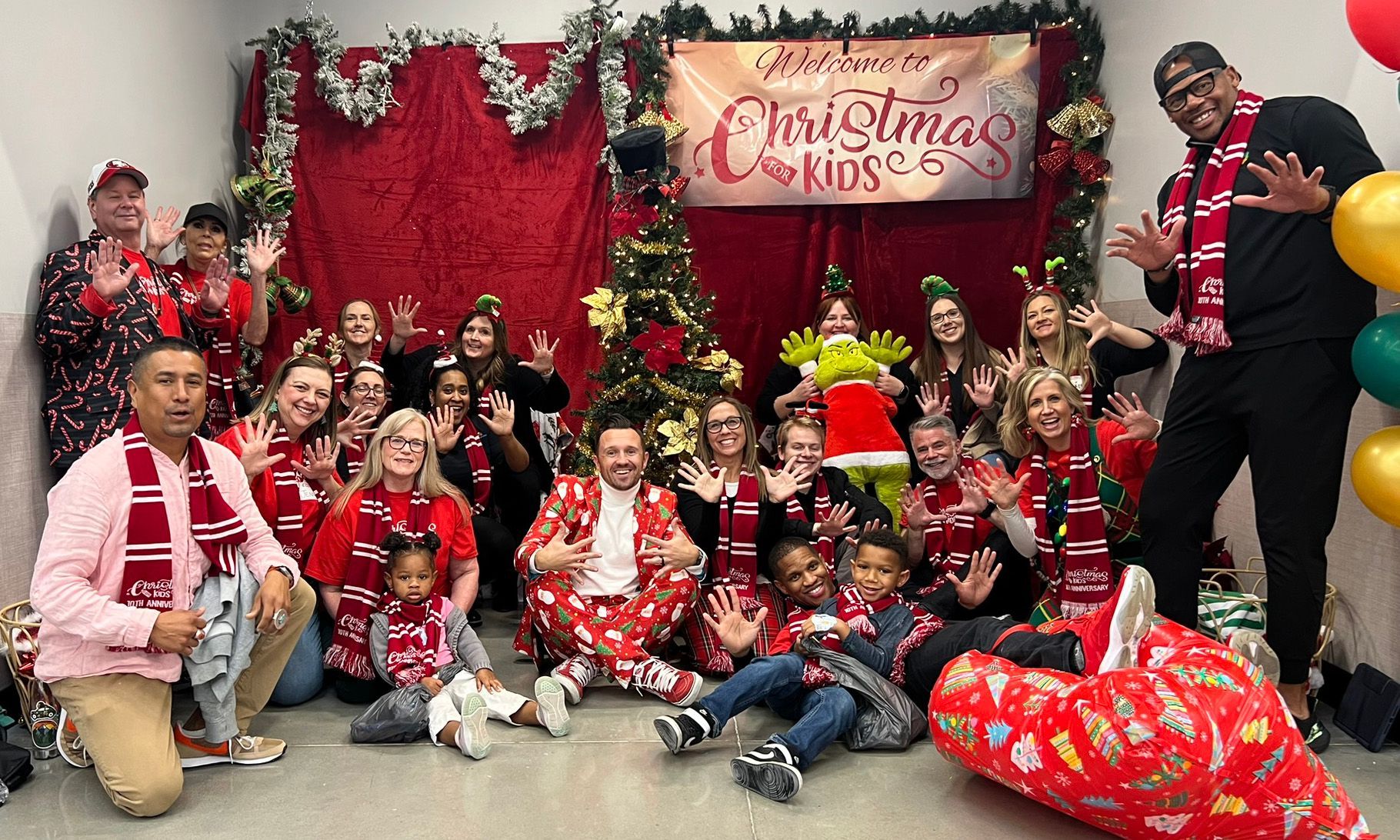 A group of people are posing for a picture in front of a christmas tree.