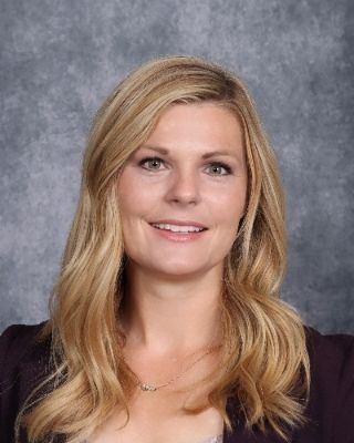 A man in a suit and tie is smiling for the camera.