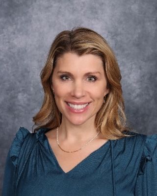 A woman in a black shirt and white bow tie is smiling for the camera.