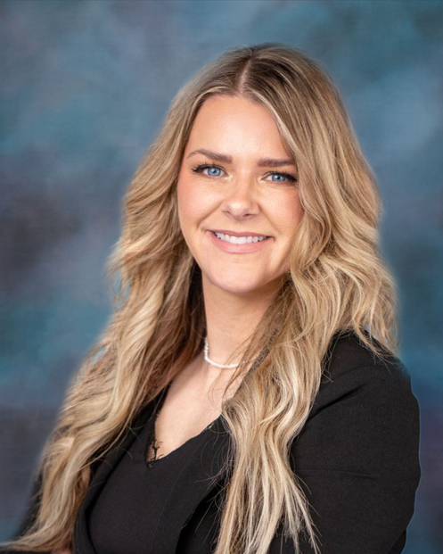 A woman with long blonde hair and blue eyes is smiling for the camera.