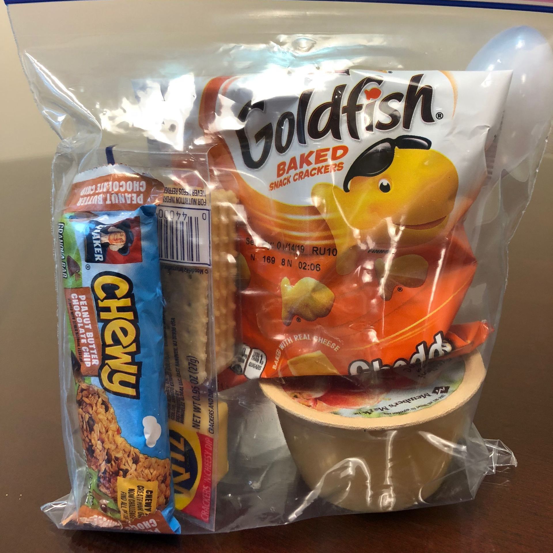 A bag of snacks including goldfish and chewy bars