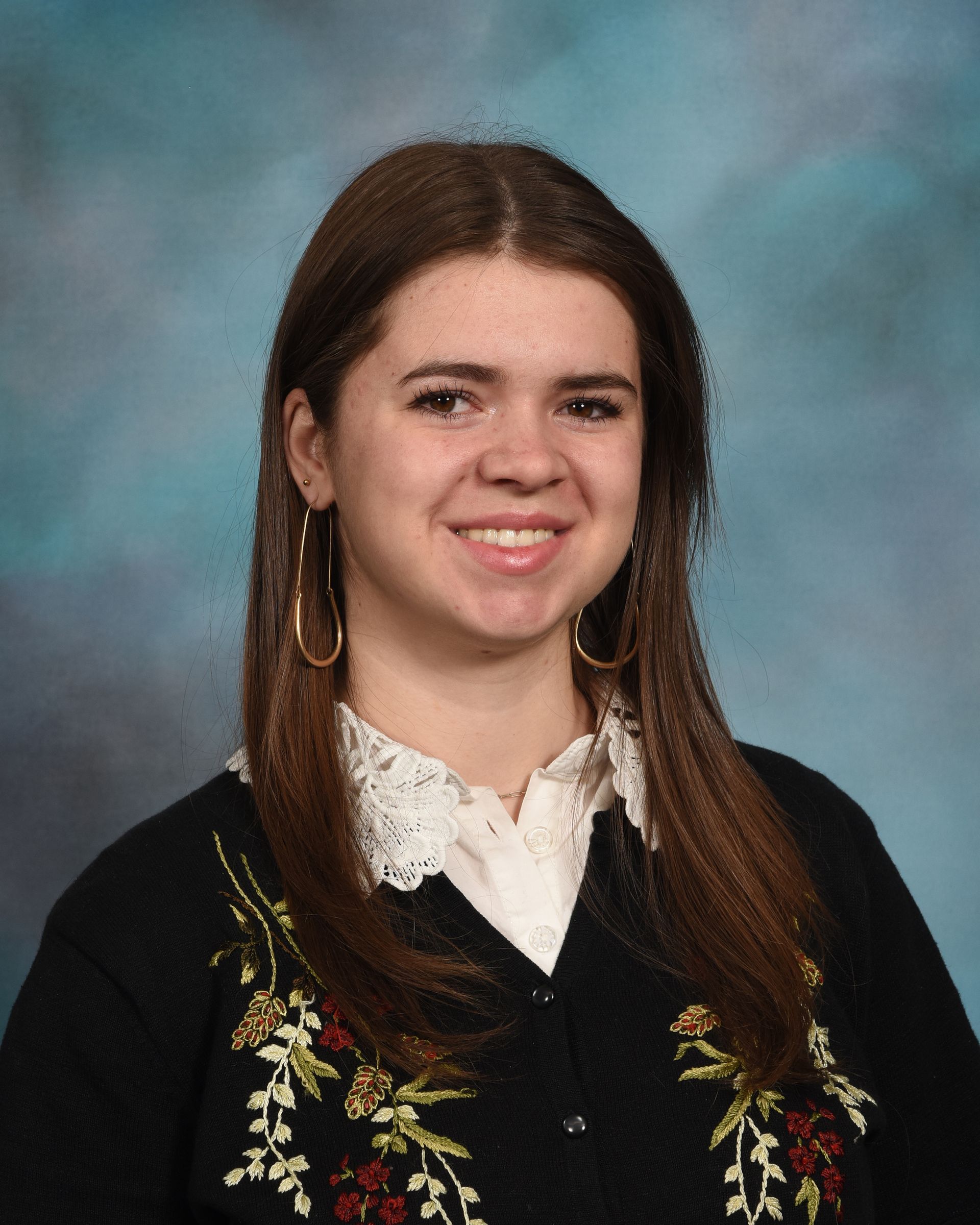 A woman wearing a black sweater with flowers on it