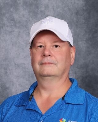 A man in a suit and pink shirt is smiling for the camera.