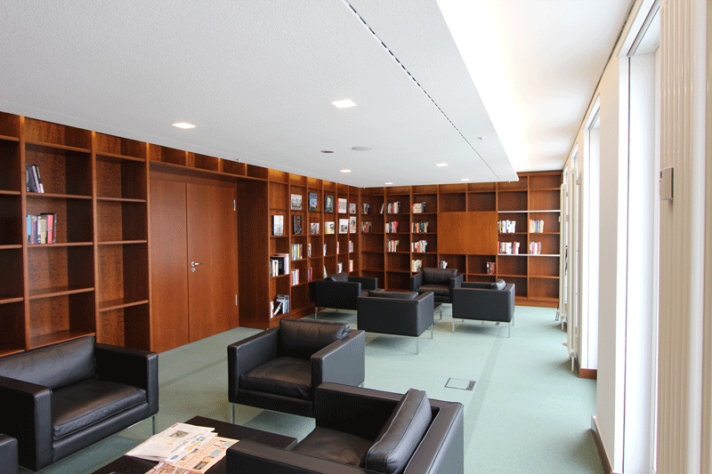 Ein Wohnzimmer mit Stühlen und Regalen voller Bücher