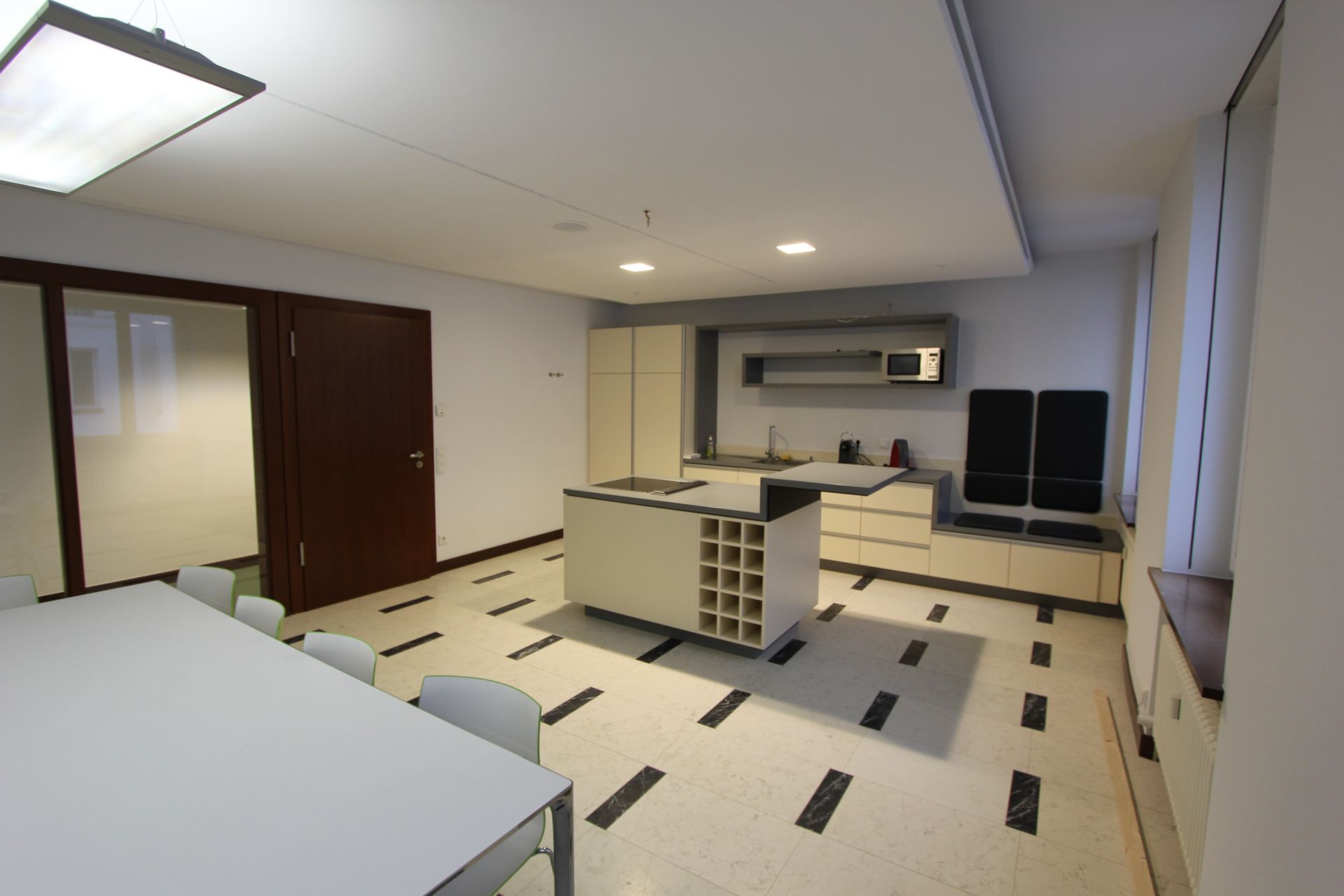 Ein Wohnzimmer mit Tisch und Stühlen und eine Küche