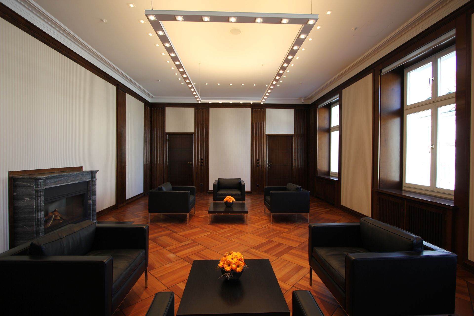 Ein Wohnzimmer mit schwarzen Möbeln und einem Kamin