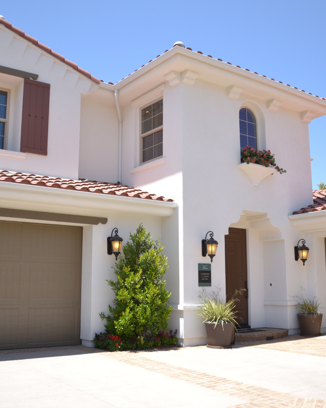 A white house with a brown garage door
