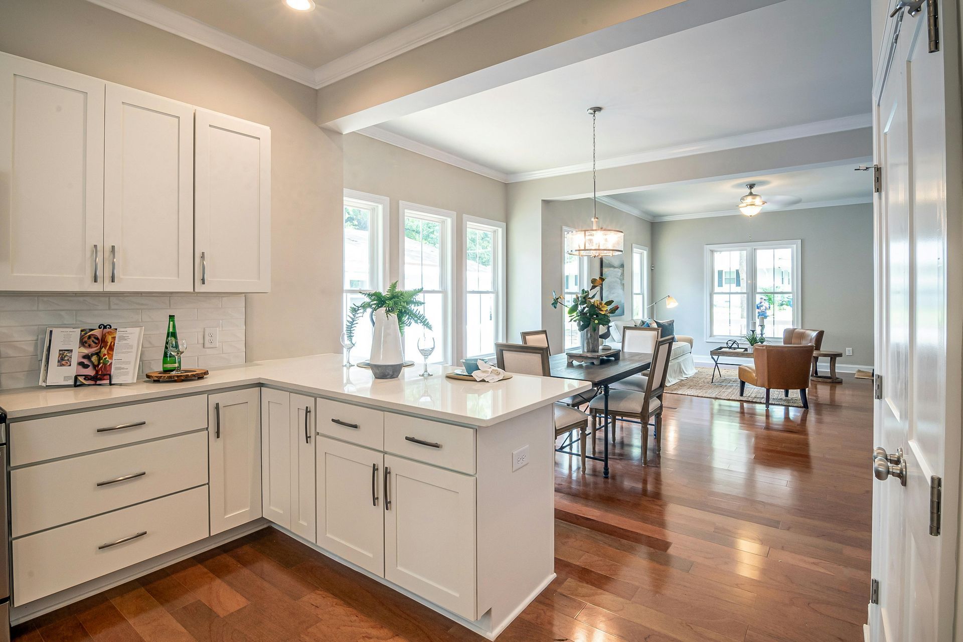A kitchen with white cabinets and a large island in the middle of the room.