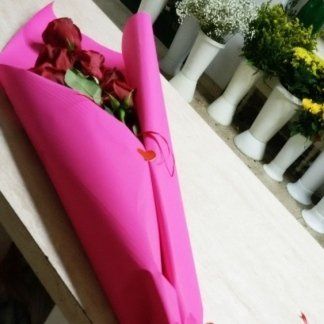 Mazzo di fiori avvolto in una carta rosa