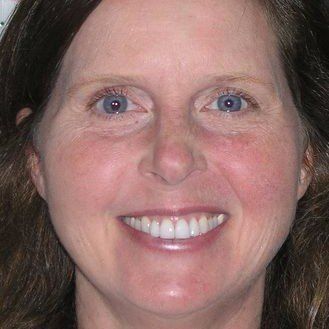 A close up of a woman 's face with a smile on her face.