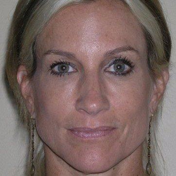 A close up of a woman 's face with earrings.