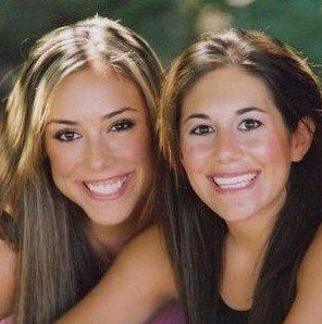 Two women are posing for a picture together and smiling for the camera.