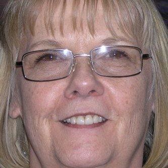 A close up of a woman wearing glasses and smiling.