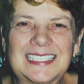 A close up of a woman 's face with a big smile on her face.