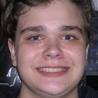 A close up of a young man 's face smiling.