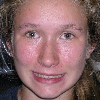 A close up of a young woman 's face with a smile on her face.