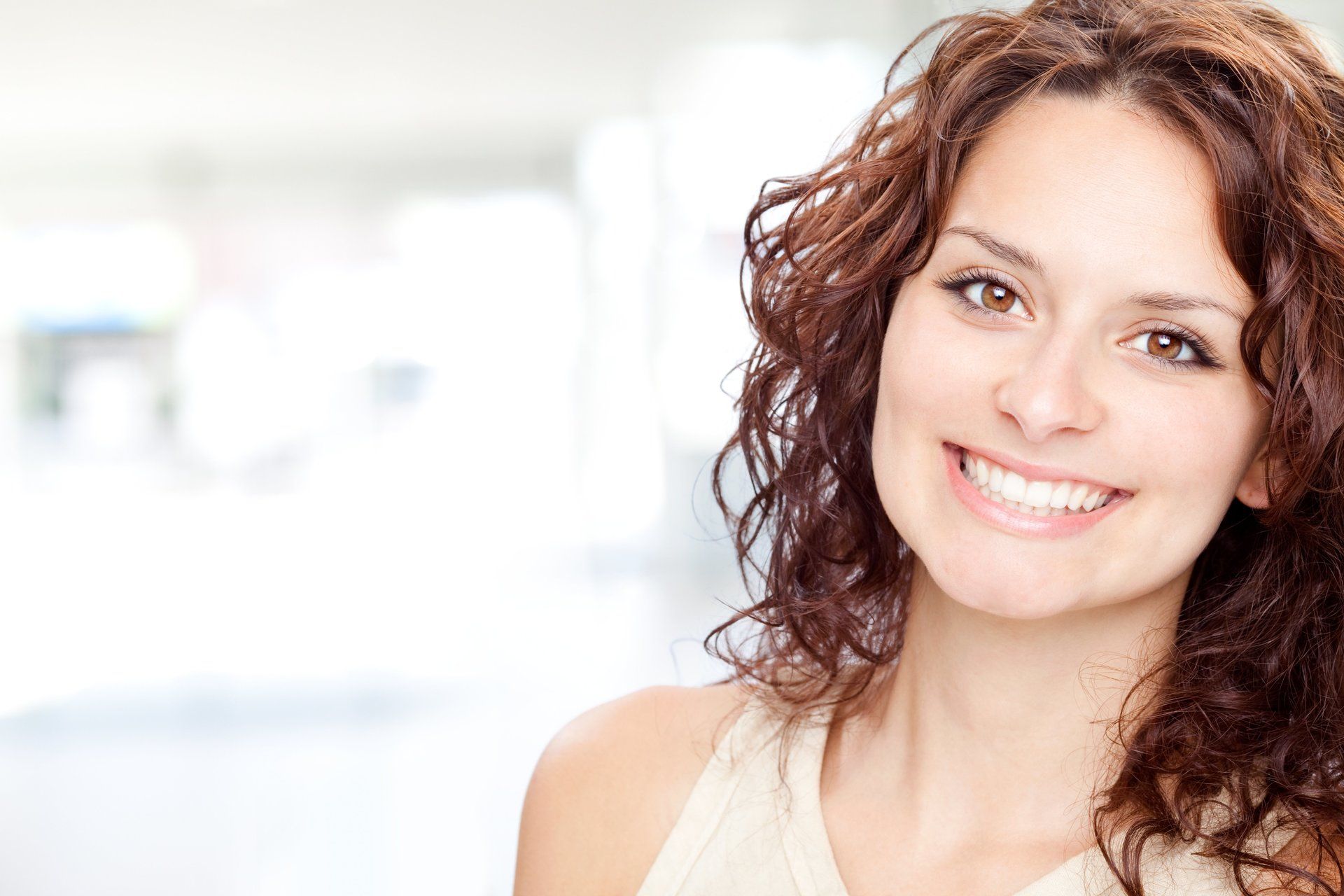 A woman with curly hair is smiling for the camera.