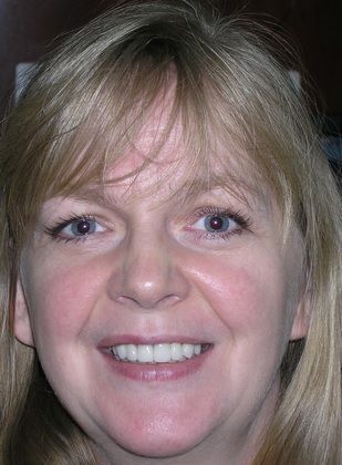 A close up of a woman 's face with a smile on her face.