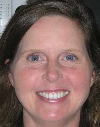 A close up of a woman 's face with a smile on her face.