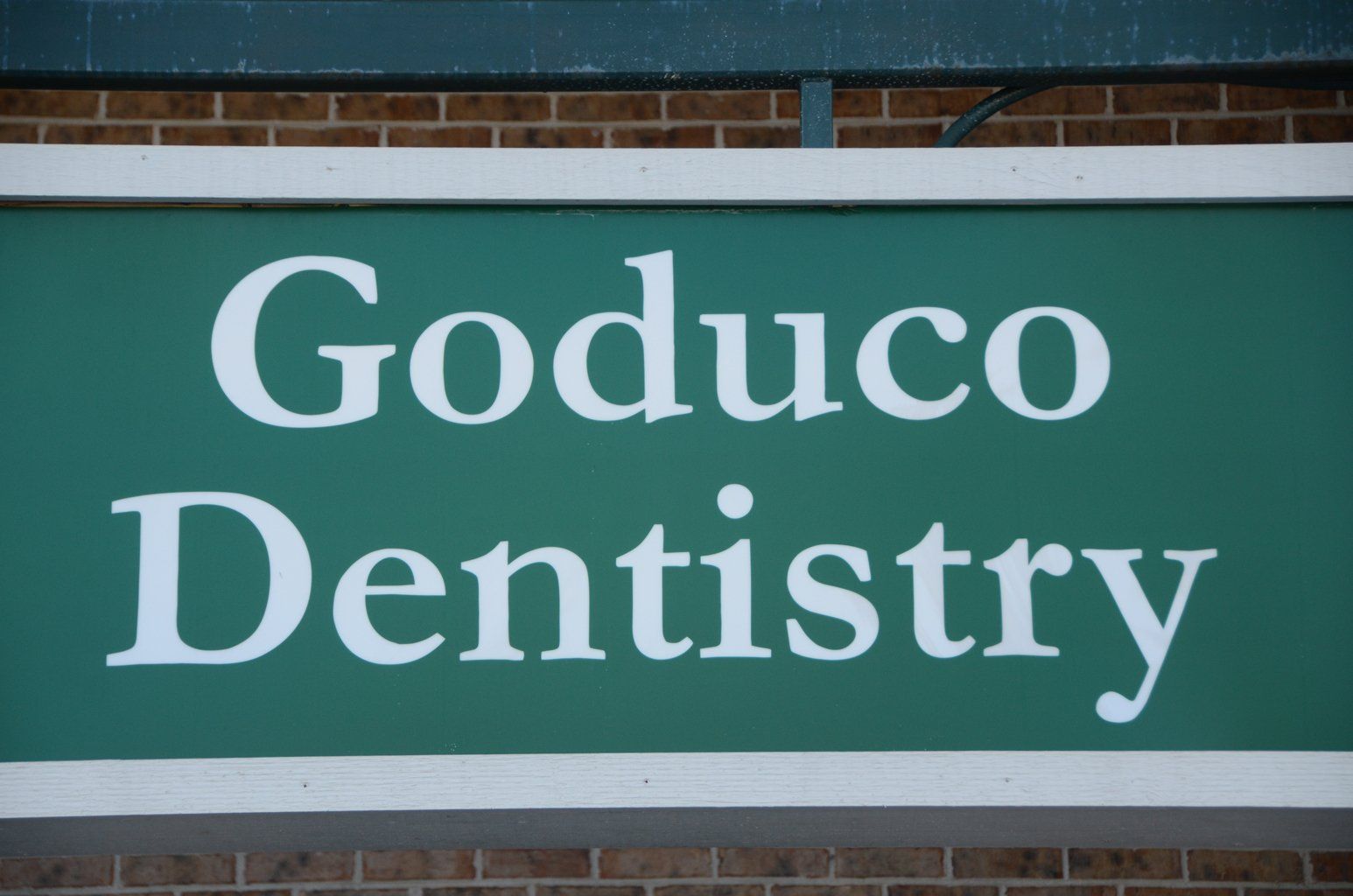 A green sign that says goduco dentistry on it