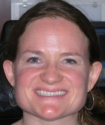 A close up of a woman 's face with a smile on her face.