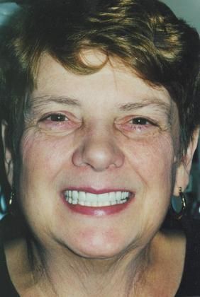 A close up of a woman 's face with a smile on her face.