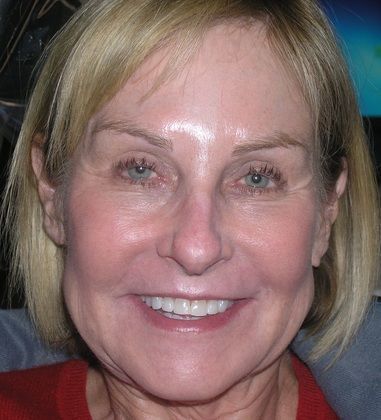 A close up of a woman 's face with a smile on her face.