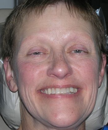 A close up of a woman 's face with a smile on her face.