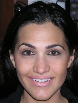 A close up of a woman 's face with a smile on her face.