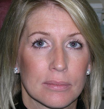 A close up of a woman 's face with blonde hair and blue eyes.