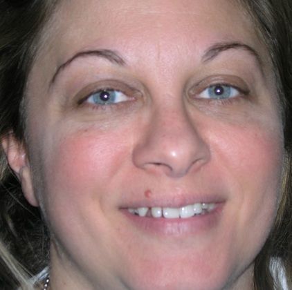 A close up of a woman 's face with a smile on her face