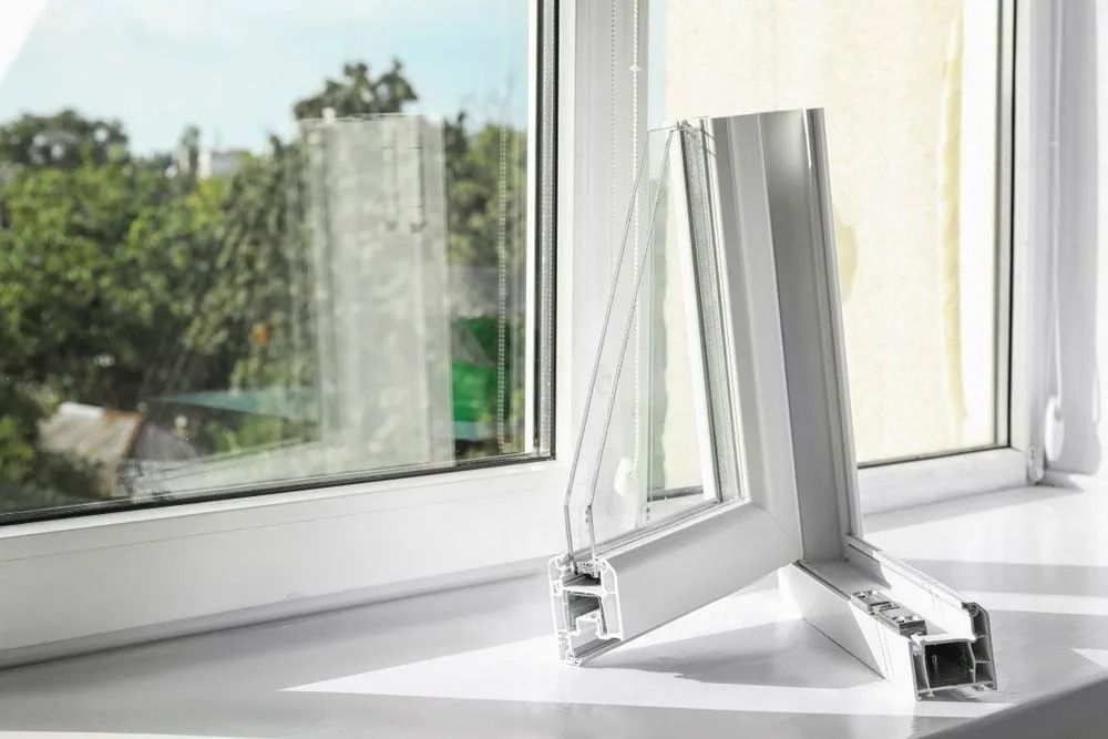 White window frame section displayed on a windowsill, showcasing multi-pane glass.