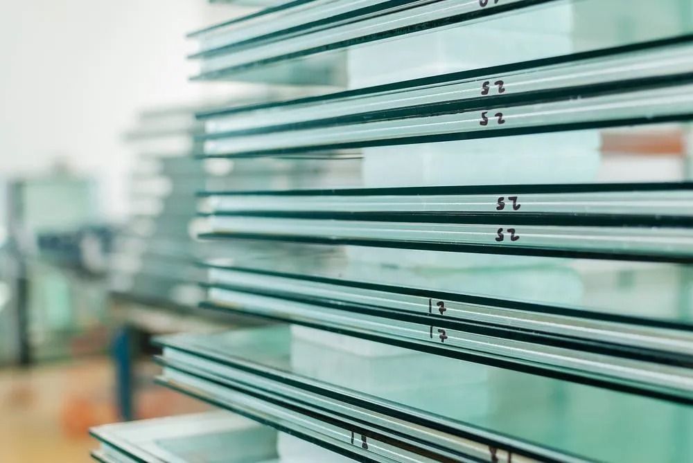 Stacked glass panels, possibly for windows, with black seals and labels.