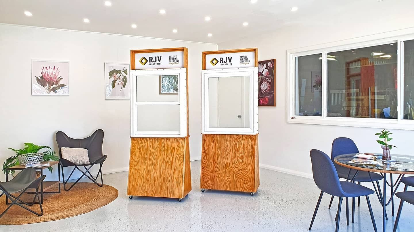 An interior space with two display units showcasing windows. There's seating, decor, and a window to the right.