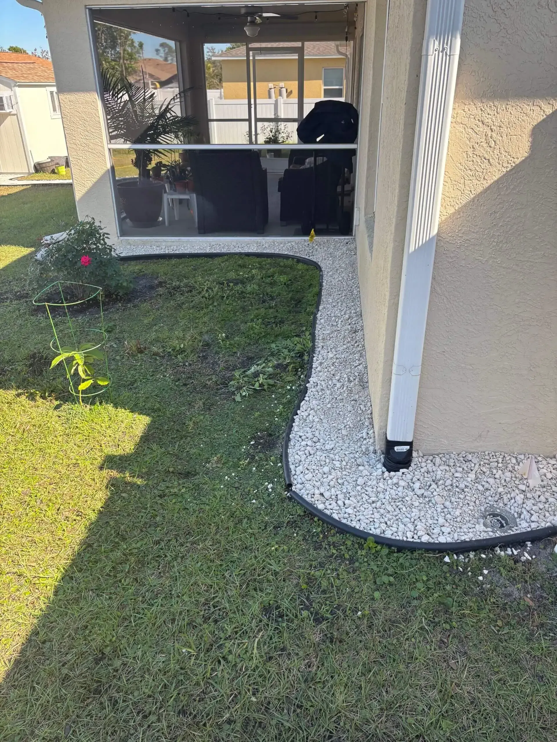 White gravel path leads to a screened porch. Green lawn on either side.