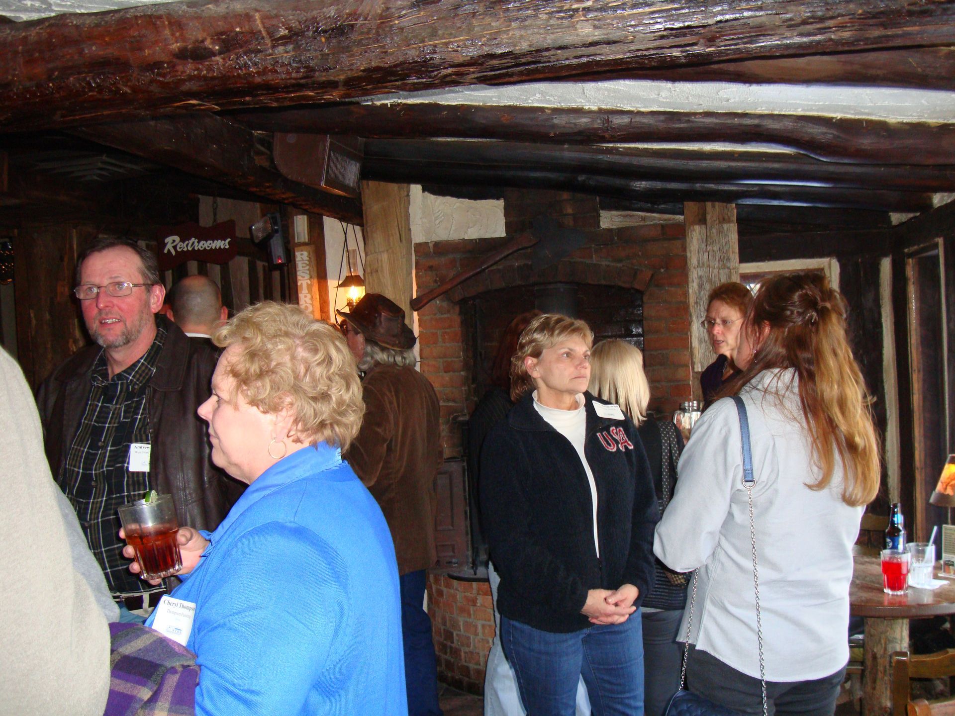 A group of people standing in a room with a sign that says budweiser