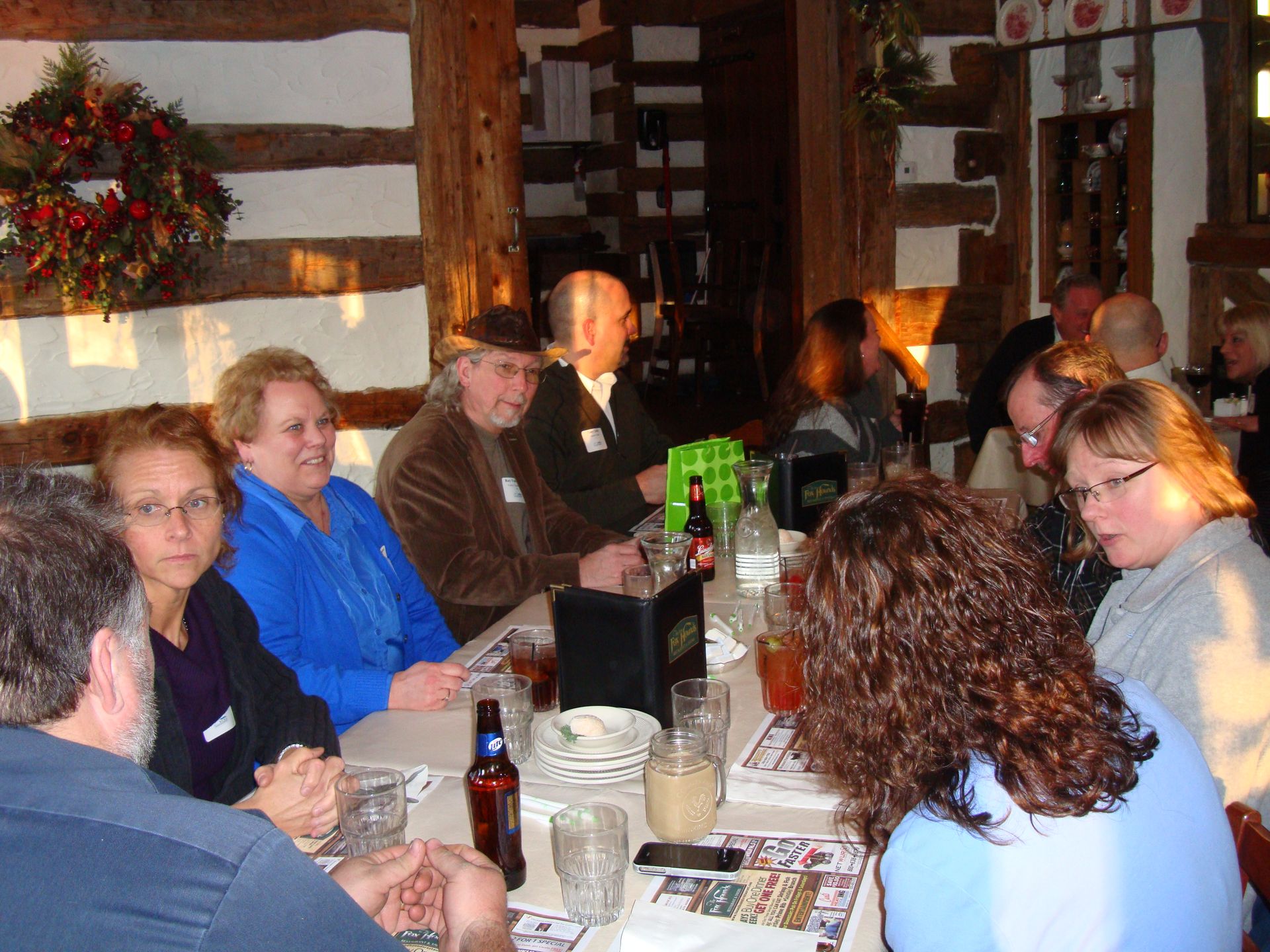 A group of people are sitting around a table with drinks