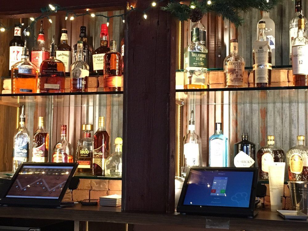 A bar with lots of bottles of liquor on shelves